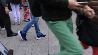 Asakusa'da taş döşeli yolda yürüyen insanların vücut parçaları