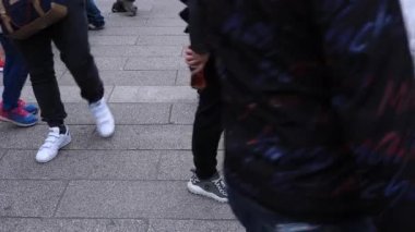 Asakusa'da taş döşeli yolda yürüyen insanların vücut parçaları