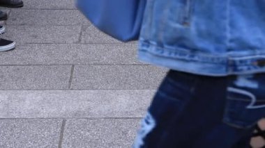 Asakusa'da taş döşeli yolda yürüyen insanların vücut parçaları