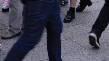 Asakusa'da taş döşeli yolda yürüyen insanların vücut parçaları