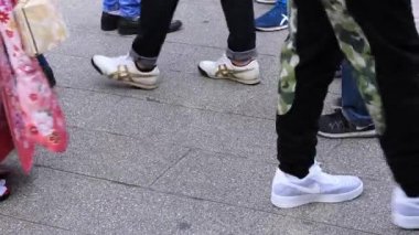 Asakusa'da taş döşeli yolda yürüyen insanların vücut parçaları