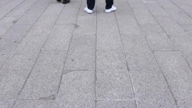 Asakusa'da taş döşeli yolda yürüyen insanların vücut parçaları