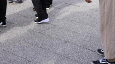 Asakusa'da taş döşeli yolda yürüyen insanların vücut parçaları