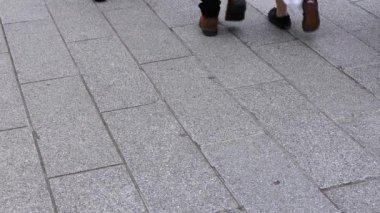Asakusa'da taş döşeli yolda yürüyen insanların vücut parçaları