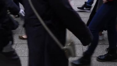 Asakusa'da taş döşeli yolda yürüyen insanların vücut parçaları