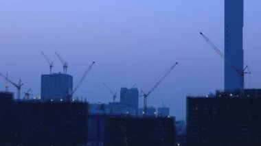 Alacakaranlıkta Ariake Tokyo'da yapım aşamasında binada vinçler