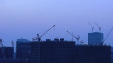 Alacakaranlıkta Ariake Tokyo'da yapım aşamasında binada vinçler