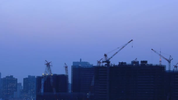 Guindastes no edifício em construção em Ariake Tokyo ao entardecer — Vídeo de Stock