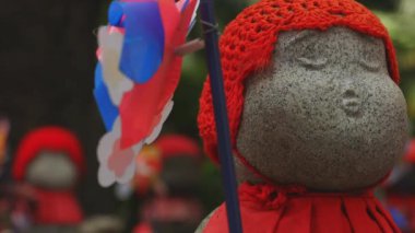 Tokyo'da gündüz kırmızı şapka giyen heykel koruyucusu