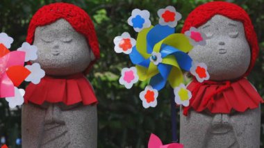 Tokyo'da gündüz kırmızı şapka giyen heykel koruyucusu