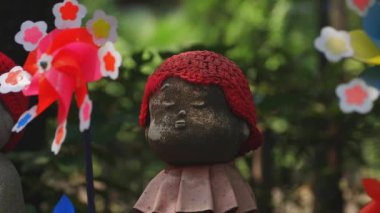 Tokyo'da gündüz kırmızı şapka giyen heykel koruyucusu