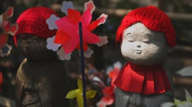Tokyo'da gündüz kırmızı şapka giyen heykel koruyucusu