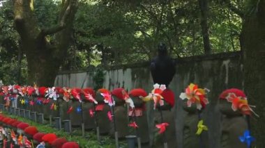 Tokyo'da gündüz kırmızı şapka giyen heykel koruyucusu