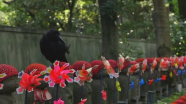 Tokyo'da gündüz kırmızı şapka giyen heykel koruyucusu
