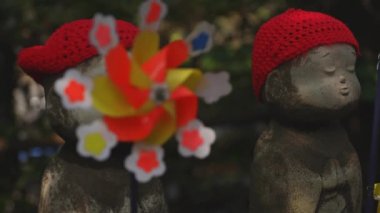Tokyo'da gündüz kırmızı şapka giyen heykel koruyucusu