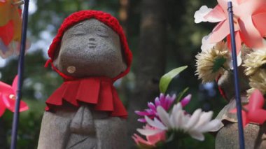 Tokyo'da gündüz kırmızı şapka giyen heykel koruyucusu