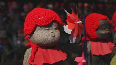 Tokyo'da gündüz kırmızı şapka giyen heykel koruyucusu