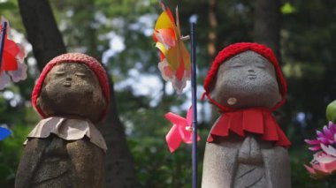 Tokyo'da gündüz kırmızı şapka giyen heykel koruyucusu