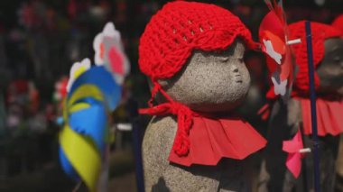 Tokyo'da gündüz kırmızı şapka giyen heykel koruyucusu