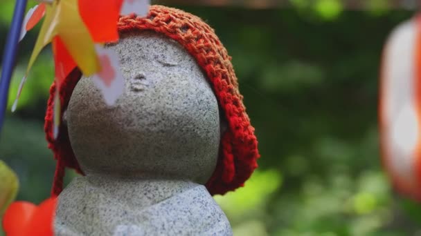 Statue gardienne portant un chapeau rouge à Tokyo de jour — Video