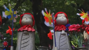 Tokyo'da gündüz kırmızı şapka giyen heykel koruyucusu