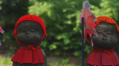 Tokyo'da gündüz kırmızı şapka giyen heykel koruyucusu