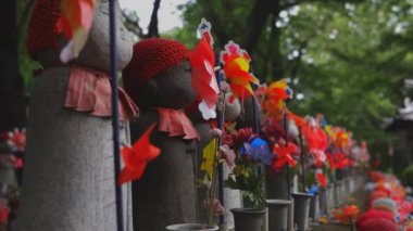 Tokyo'da gündüz kırmızı şapka giyen heykel koruyucusu