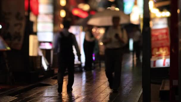 Gente che cammina per la strada al neon del centro di Nakano Tokyo giorno di pioggia — Video Stock