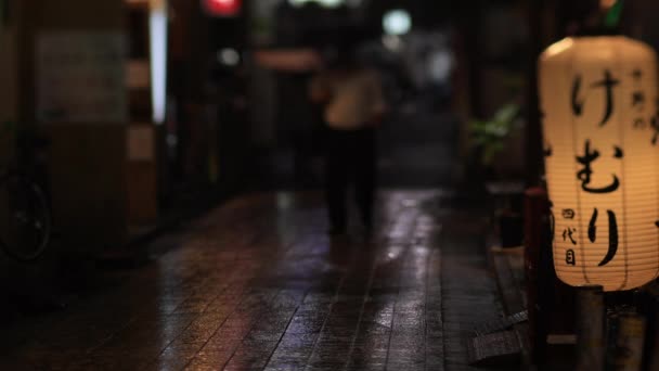 Promenader människor på centrum neon gatan i Nakano Tokyo regnig dag — Stockvideo