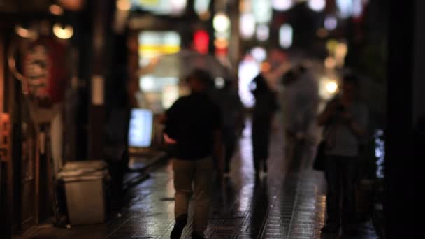 Lopende mensen in de binnenstad neon straat in Nakano Tokyo regenachtige dag — Stockvideo