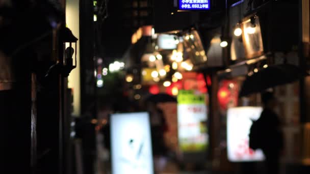 东京中野雨天，人们在市中心的霓虹灯街上散步 — 图库视频影像