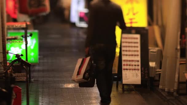 东京中野雨天，人们在市中心的霓虹灯街上散步 — 图库视频影像