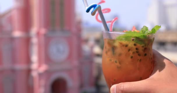 Тропический сок с рукой позади церкви Тан Динь в Хошимине, сосредоточенный — стоковое видео