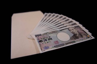 Japon para birimi 100,000 yen ve siyah arkaplanda zarf.