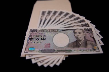 Japon para birimi 100,000 yen ve siyah arkaplanda zarf.
