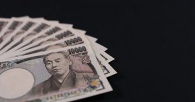 Japon para birimi 100,000 yen ve siyah arkaplanda zarf var.
