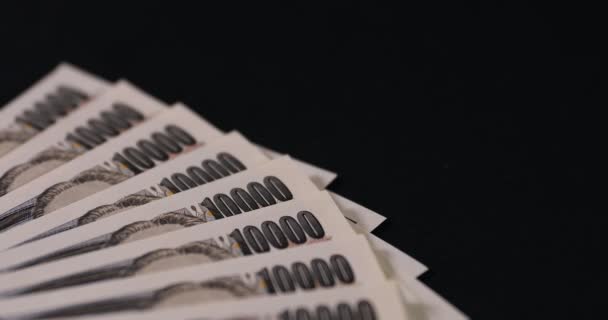 Japansk valuta 100.000 yen på svart bakgrund lutning fokus — Stockvideo