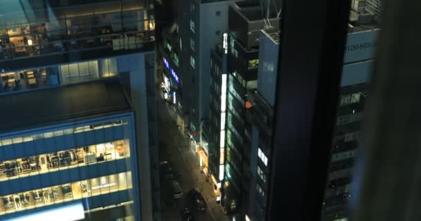 Ein nächtliches Stadtbild aus dem fallenden Aufzug in der Großstadt in Tokio hoch oben — Stockvideo