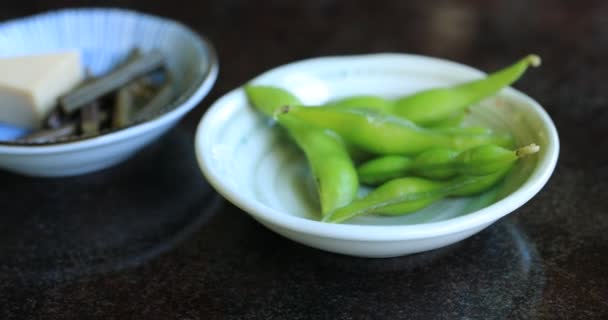 손에 든 점심 식사에서 일본 요리에 들어 있는 식욕을 돋우는 초록빛 콩 — 비디오