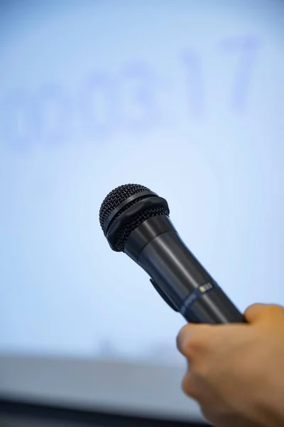 Een microfoon met linkerhand achter het witte bord op kantoor — Stockfoto