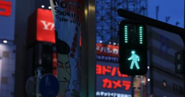 Gece Shinjuku 'daki neon kasabasında mavi bir trafik ışığı.