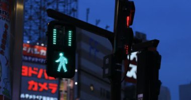 Gece Shinjuku 'daki neon kasabasında mavi bir trafik ışığı.