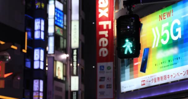 Un semaforo che cambia da blu a rosso nella città al neon di Shinjuku di notte — Video Stock