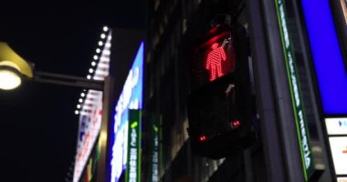 Gece Shinjuku 'daki neon kasabasında trafik kırmızı ışığı.