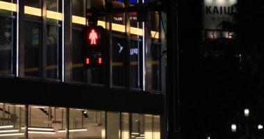 Gece Shinjuku 'daki neon kasabasında trafik kırmızı ışığı.