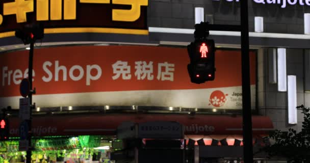 В неоновом городке Синдзюку ночью светофор меняет красный на синий. — стоковое видео