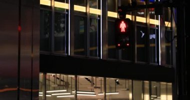 Gece Shinjuku 'daki neon kasabasında trafik ışığı kırmızıya dönüyor.