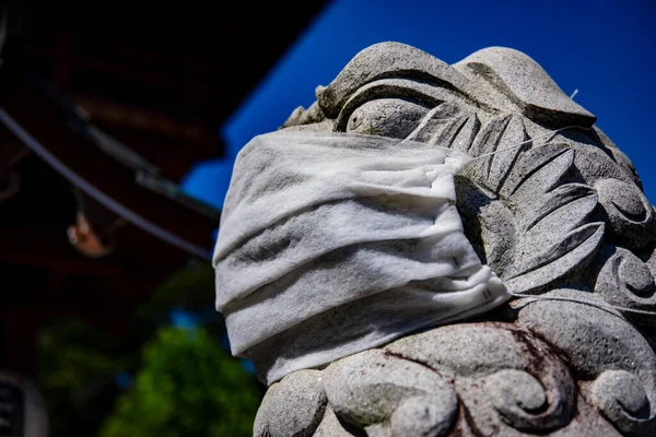 A statue of Guardian dog wearing mask at Meguro fudo temple in Tokyo closeup — Stock Photo, Image
