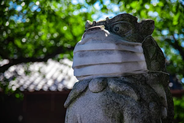 A statue of Guardian dog wearing mask at Meguro fudo temple in Tokyo closeup — Stock Photo, Image