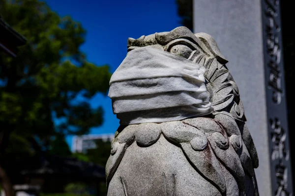 Une statue de chien gardien portant un masque au temple Meguro fudo à Tokyo gros plan — Photo